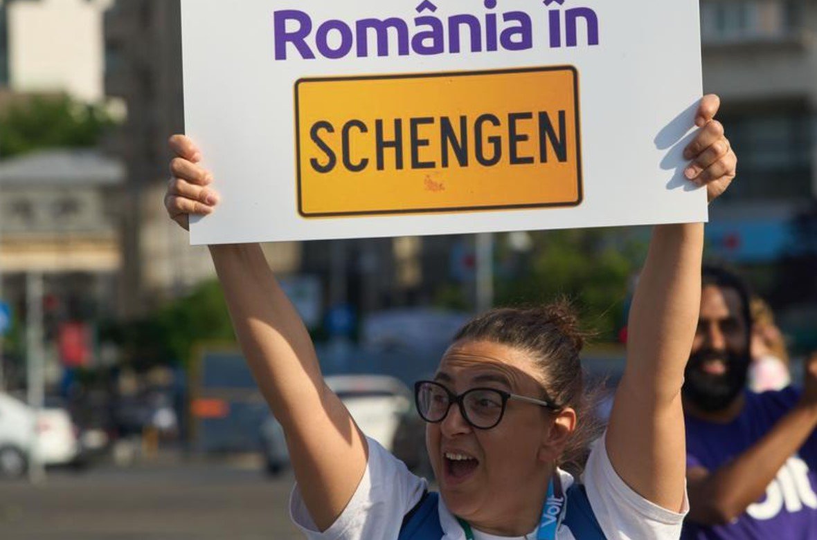 A protester holding a placard saying "Romania in Schengen" - Bulgaria and Romania Secure Schengen Approval